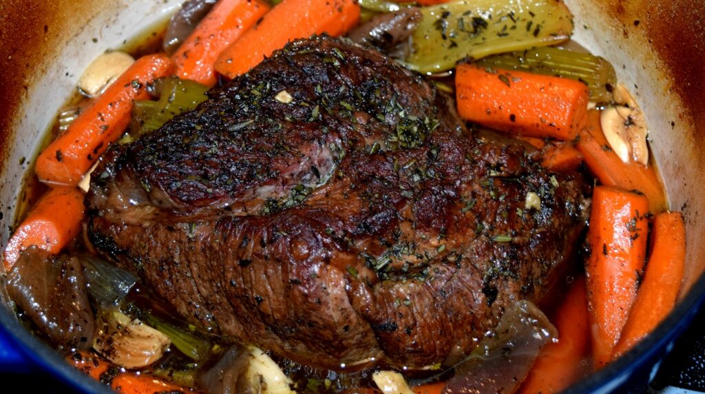 Ultra close up macro food photography of tender slow cooked beef chuck roast with carrots and rich pan gravy